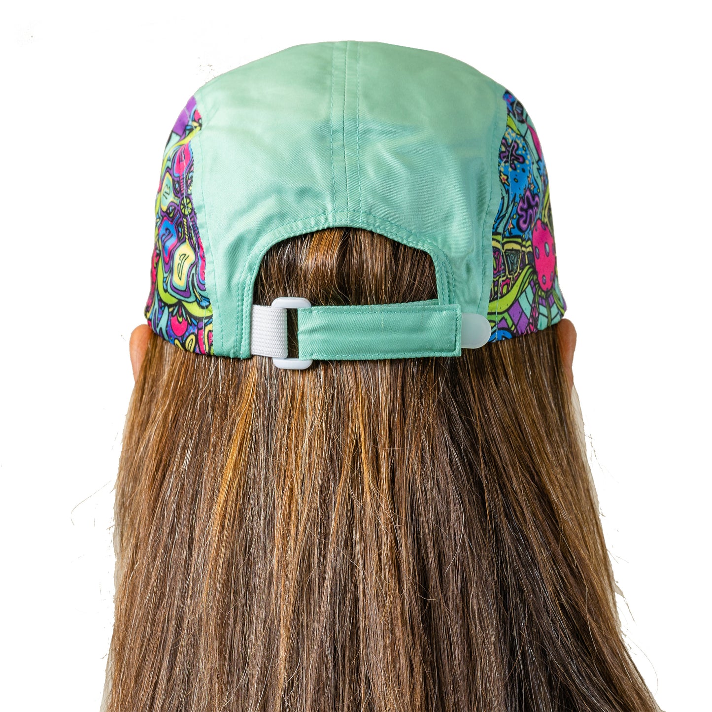 Woman models a five-panel mint green running hat with a colorful graphic design on the sides. The hat features an adjustable plastic snap closure.