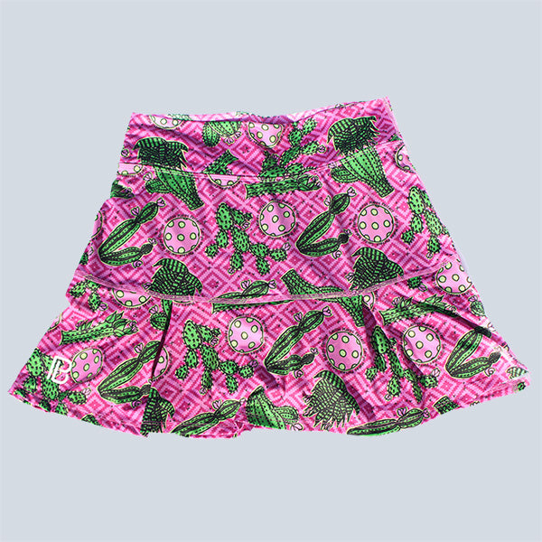 Pink athletic skort displays a vibrant green cactus and pickleball print.