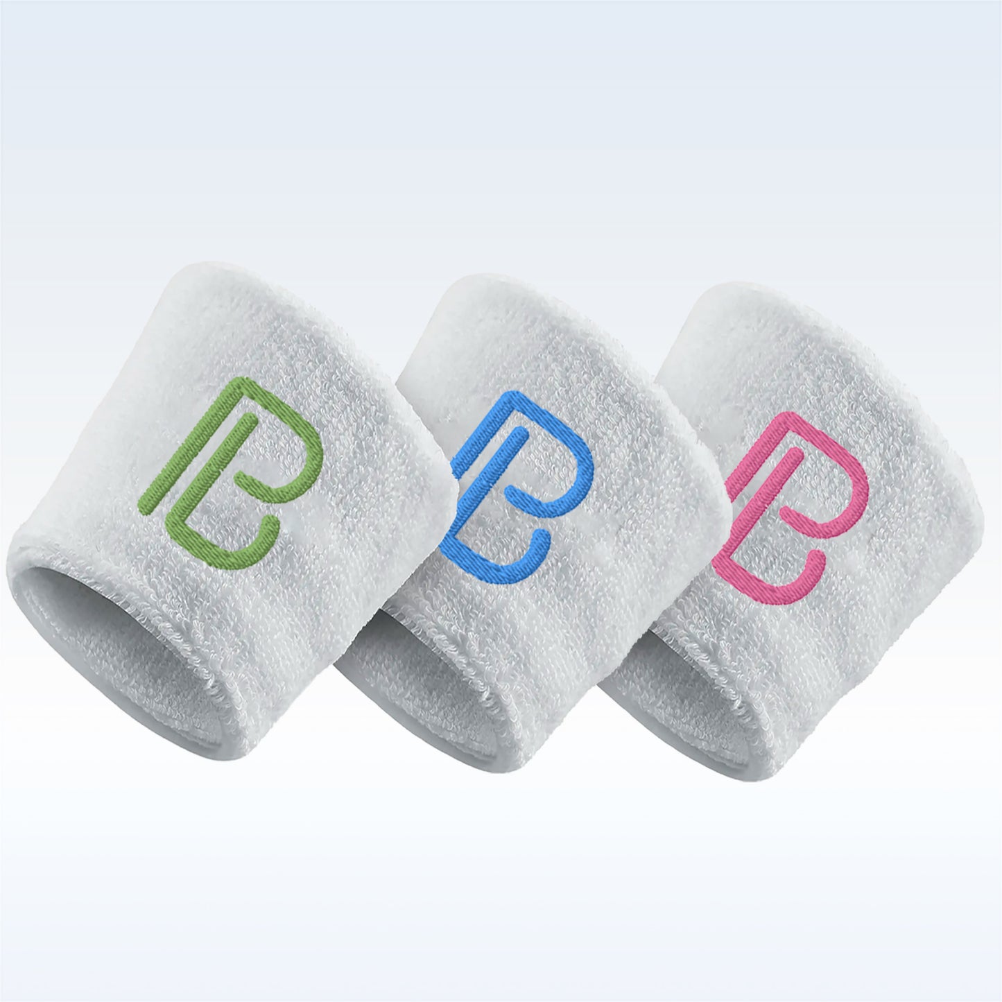 Three white terrycloth wristbands showcase embroidered "B" logos in green, blue, and pink.