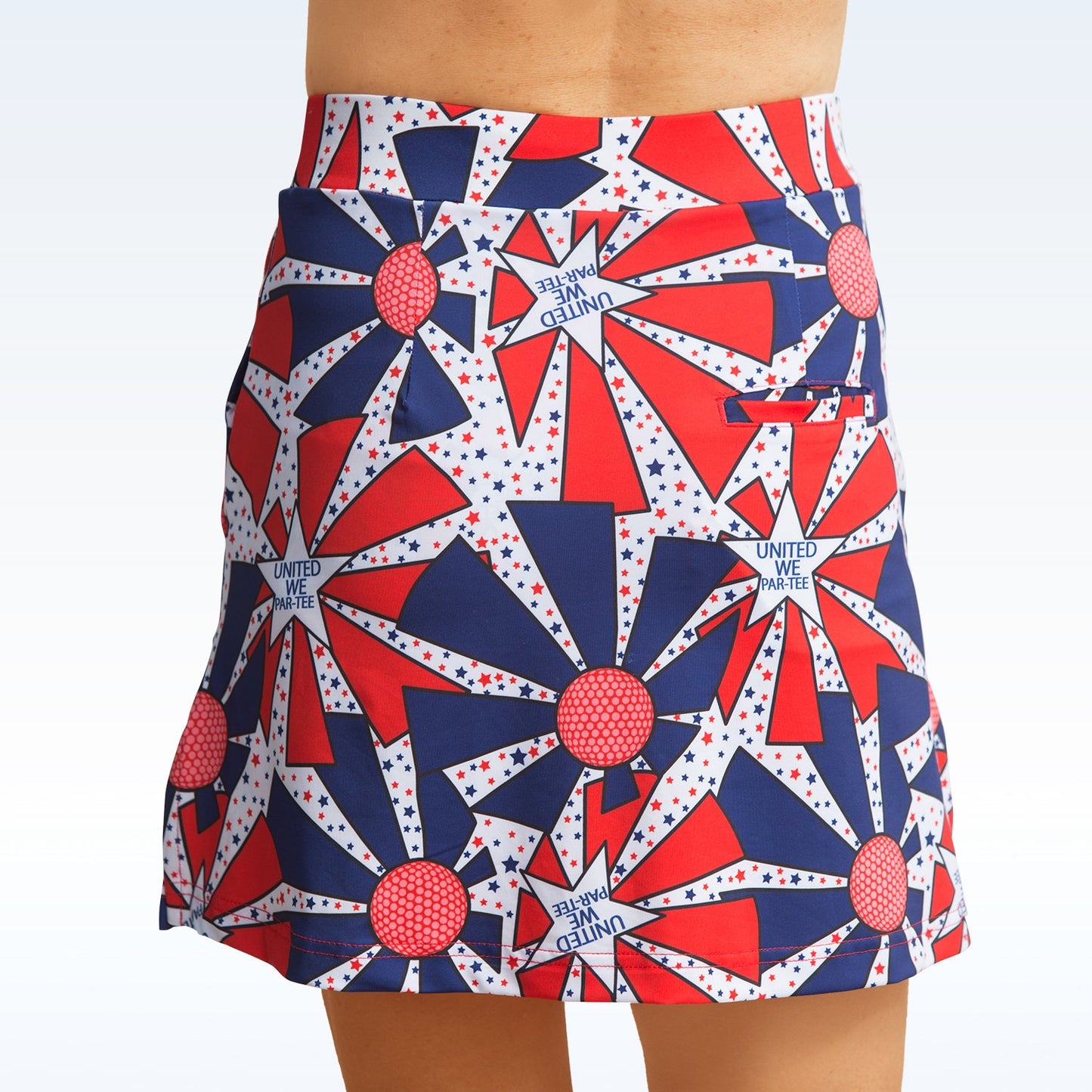 Woman models a red, white, and blue golf skort with a starburst pattern. The skort features a back pocket.