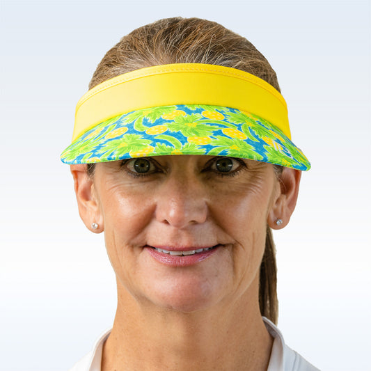 Woman smiles wearing a yellow and blue floral visor.