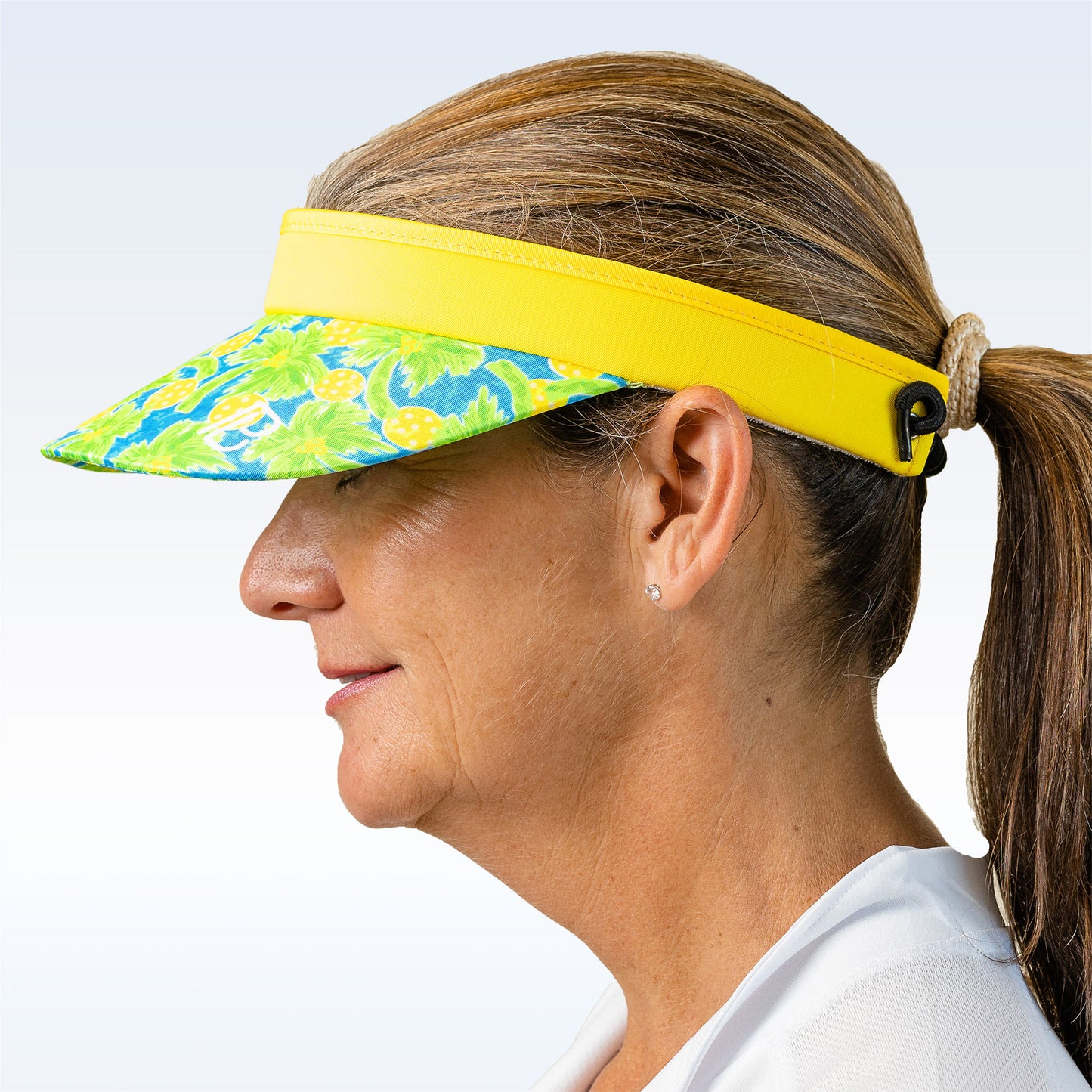 Woman models a blue and green floral visor with a bright yellow brim.
