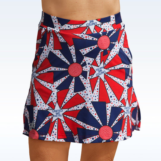 Woman models a red, white, and blue golf skort featuring a starburst and golf ball pattern. 
